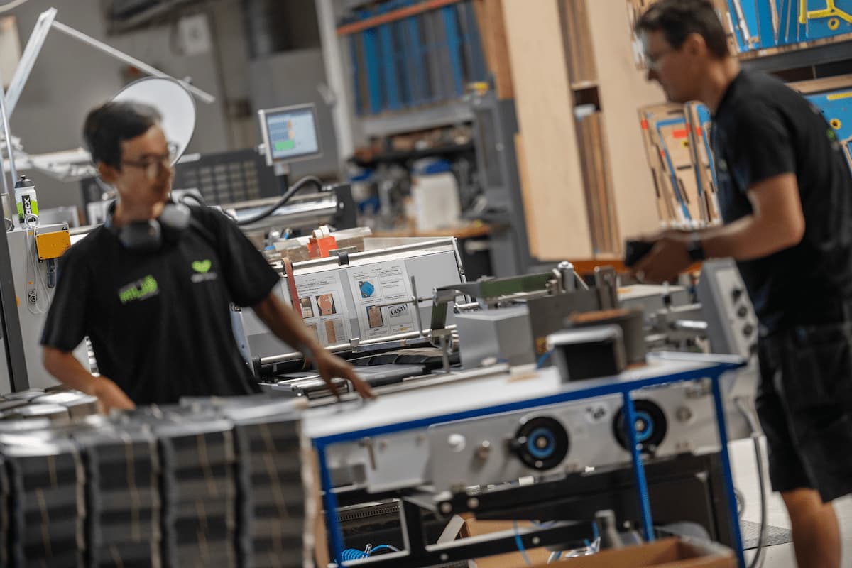 To medarbejdere arbejder ved en produktionsmaskine hos KLS PurePrint